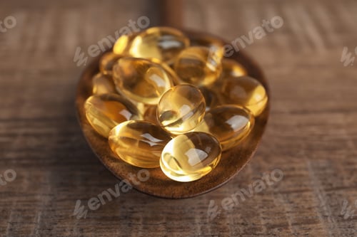 Preview: Spoon with cod liver oil pills on table, closeup