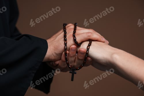 Preview: Priest and woman holding hands on brown background, closeup