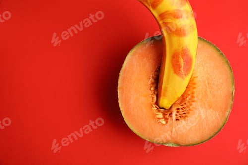 Preview: Flat lay composition with fresh banana and melon on red background. Sex concept