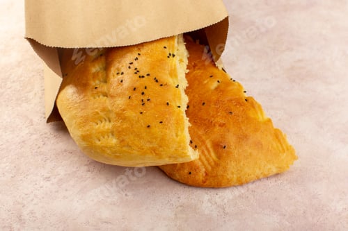 Preview: a top view baked bread hot tasty fresh half sliced inside and outside paper packages on the pink