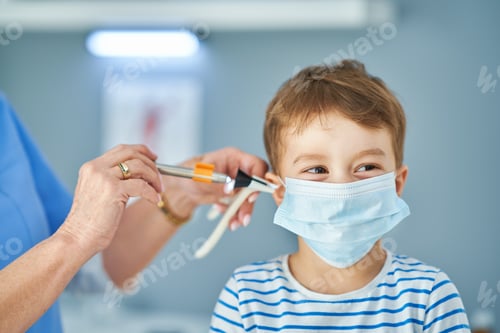 Preview: Pediatrician doctor examining little kids in clinic ears check