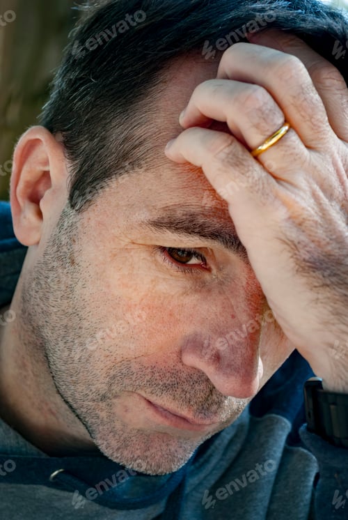 Preview: Worried man thinking with his hand on his forehead