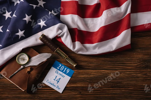 Preview: top view of calendar with Columbus Day inscription near leather notebook, nib, telescope and compass