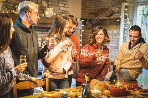 Preview: Happy friends group celebrating Christmas party with white wine