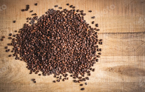 Preview: Roasted brown coffee beans spilled on wooden table background.