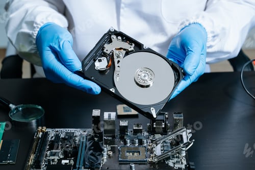 Preview: Hard disk drive on the technician's desk and a computer motherboard as a component. the concept