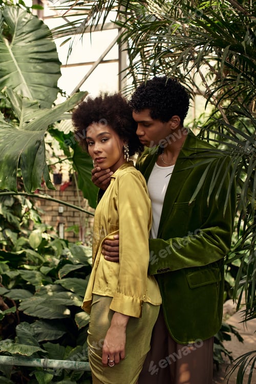 Preview: Young couple in a lush greenhouse share a moment of tenderness surrounded by vibrant plants