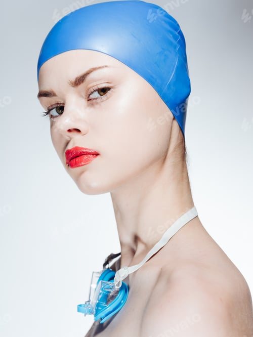 Preview: Sexy woman in blue swimming cap diving naked shoulders light background