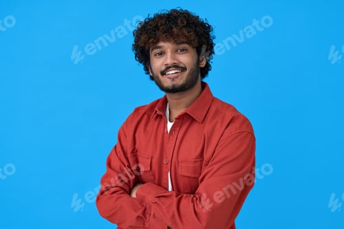Preview: Smiling young indian guy standing isolated on blue background.