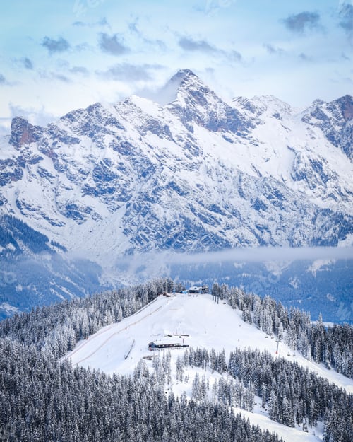 Preview: Mesmerizing landscape of a snowy forested hillside on the background of the majestic hills
