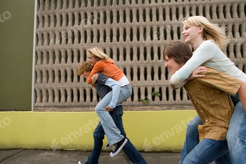 Preview: Four teenagers running piggy back races