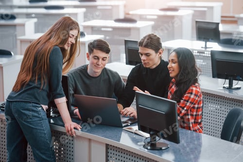 Preview: Active conversation. Group of young people in casual clothes working in the modern office