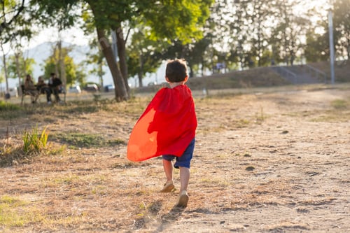 Preview: Boy playing superhero outdoors imagining adventure