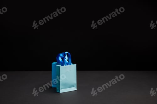 Preview: close up view of blue shopping bags on black backdrop