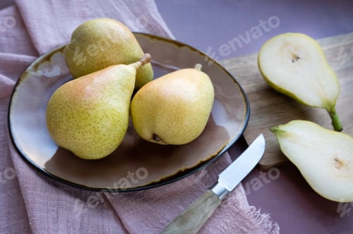 Preview: whole pears on a plate, accompanied by juicy cut halves on a board.