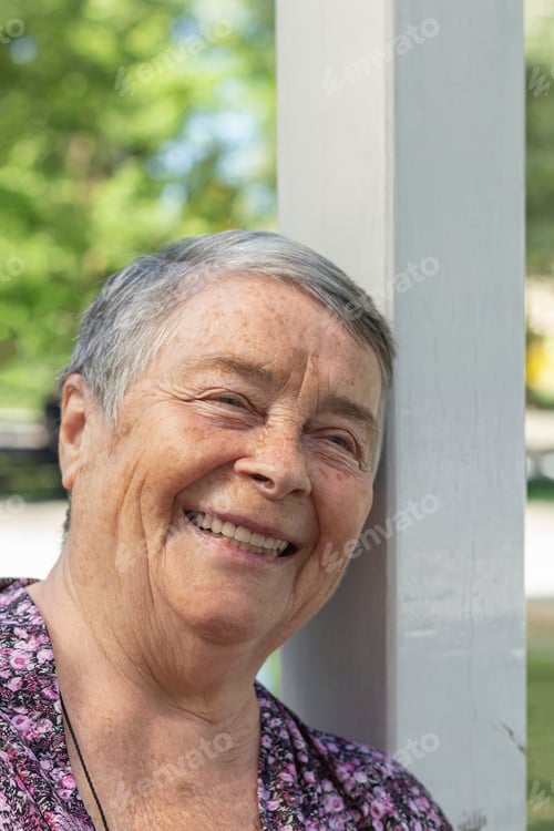 Preview: Pretty, senior woman chatting with friends, laughing outdoors, enjoying on walk outdoors in summer