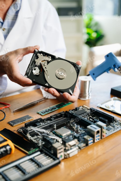 Preview: Technician repairing inside of hard disk drive by screwdriver. the concept of data, hardware,