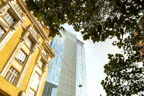 Preview: Perspective view of modern high-rise glass skyscraper and old buildings in city center