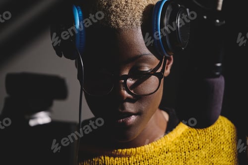 Preview: Pensive African American woman in headphones near microphone