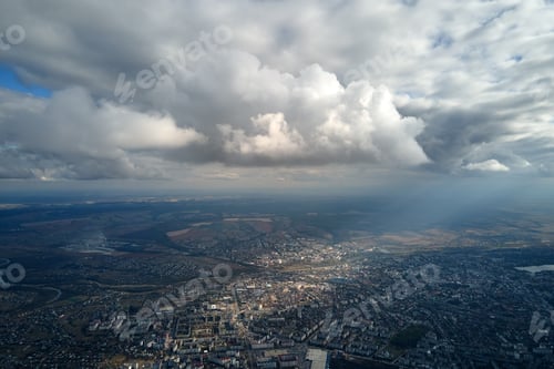 Preview: Aerial view from airplane window at high altitude of distant city