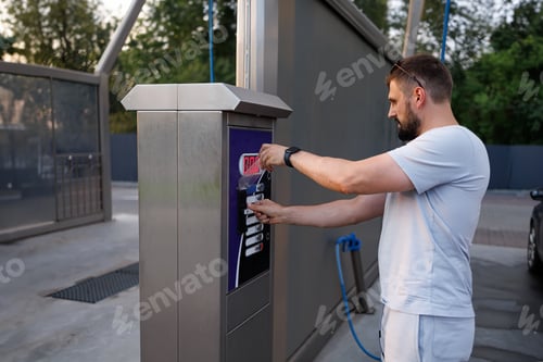 Preview: A person pays to have their car washed. A car at a self service car wash.