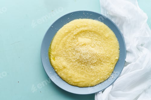 Preview: Urkainian polenta porridge on pastel turquoise aquamarine background top view copy space