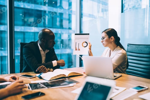 Preview: Woman showing chart to colleague in office
