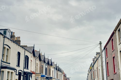 Preview: Low angle view of terraced houses with telegraph pole and wires, Maryport, Cumbria, UK
