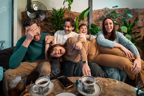 Preview: Group of friends laughing at cafe table