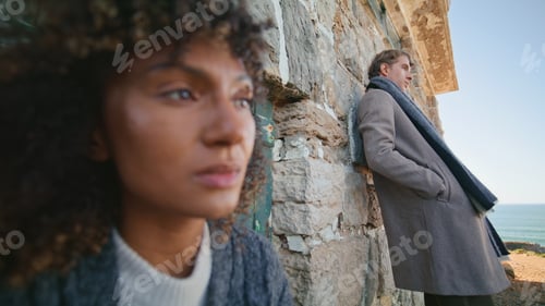 Preview: Romantic models posing rocks looking distance at ocean closeup. Serious couple