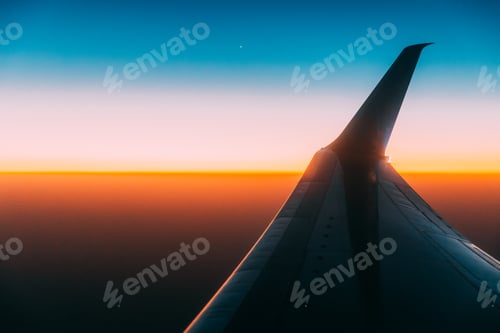 Preview: Close View Of On Wing Of Aircraft. Plane At Sunset Sky. View From Airplane Window On Height Flight