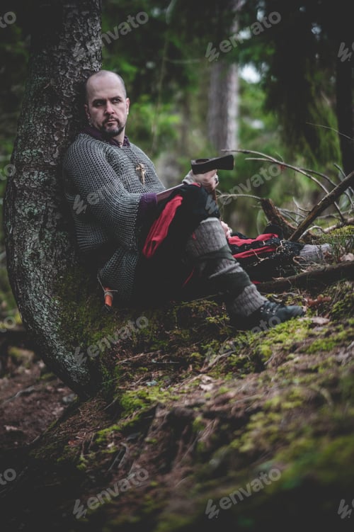 Preview: Man dressed in authentic medieval armor standing in the middle of forest