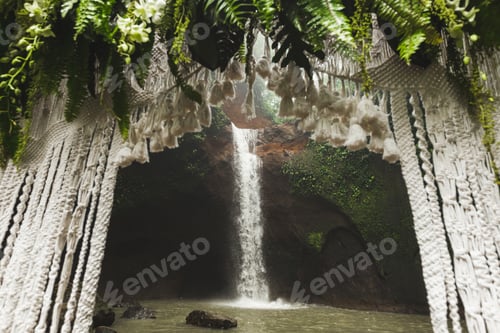 Preview: Tropical wedding ceremony with waterfall view. White arch decorated with green jungle leaves