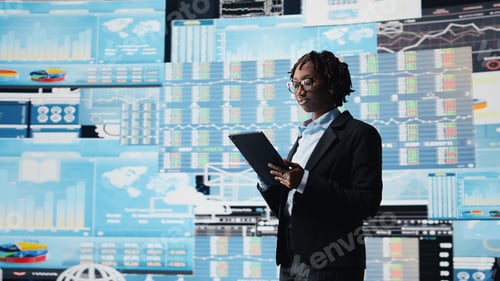 Preview: Manager using tablet to compare company metrics on digital videowall