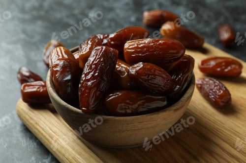 Preview: Board with bowl of dried dates on black smokey background
