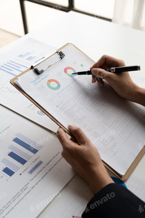 Preview: Close up view of young businesswoman working on her project with graph and charts, analyzing the
