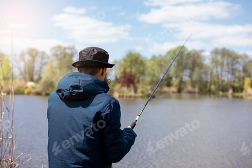 Preview: fishing rod on lake water background. Man catching fish by spinning on lakeside