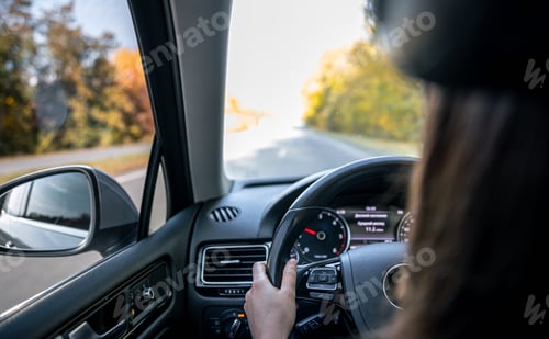 Preview: Woman driver's hands on the steering wheel inside the car.