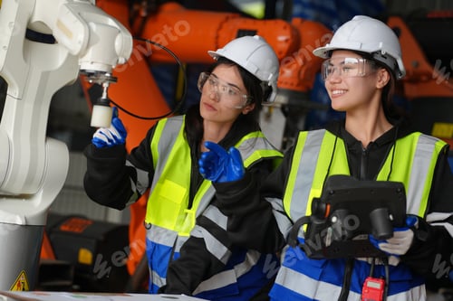 Preview: Female Engineer check and control automation robot arms machine in factory. robotics manufacturing.
