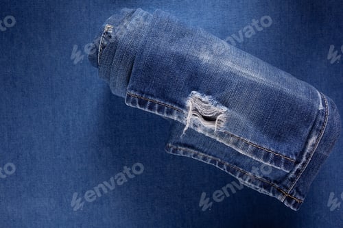 Preview: Folded blue jeans denim background texture. Jeans fabric material surface