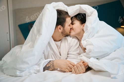 Preview: Young husband and wife kiss cute under the covers