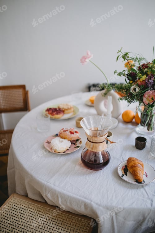 Donuts, Coffee and Flowers on a White Table