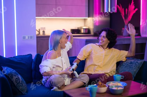 Preview: Young couple gamers winners playing winning video game, excited woman having fun with man give high