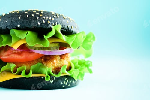 Preview: Macro view of tasty black burger with beef, cheese, lettuce, onion, tomatoes on blue background