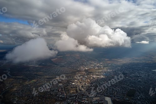 Preview: Aerial view from airplane window at high altitude of distant city