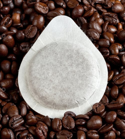 Preview: Single coffee pod laying on coffee beans