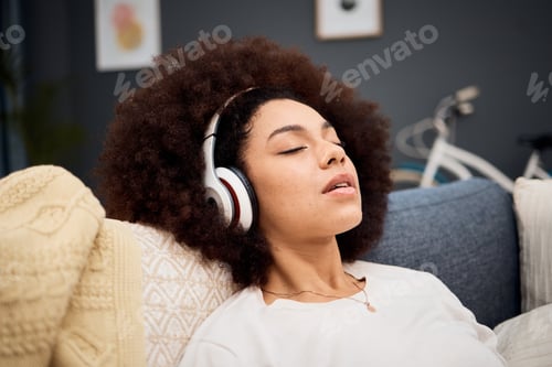 Preview: Music, relax and black woman on a sofa listening to radio, streaming or wellness podcast in a livin