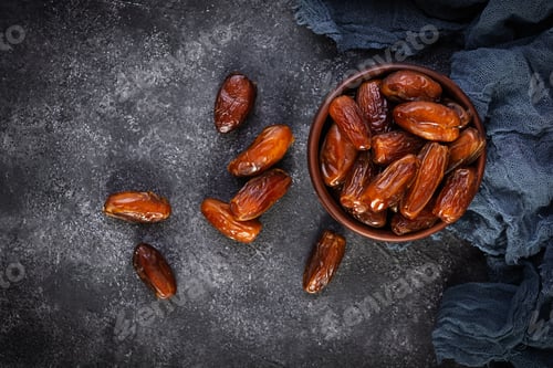 Preview: Dried date fruit in bowl on wooden background. Delicious dates fruit. Top view