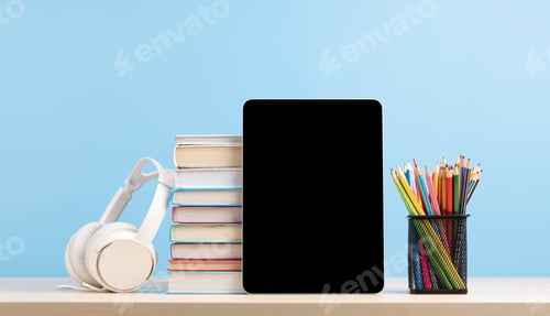Preview: Tablet with colorful pencils and stack of books