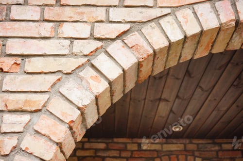Preview: Low angle closeup shot of part of the arch of a cobblestone building